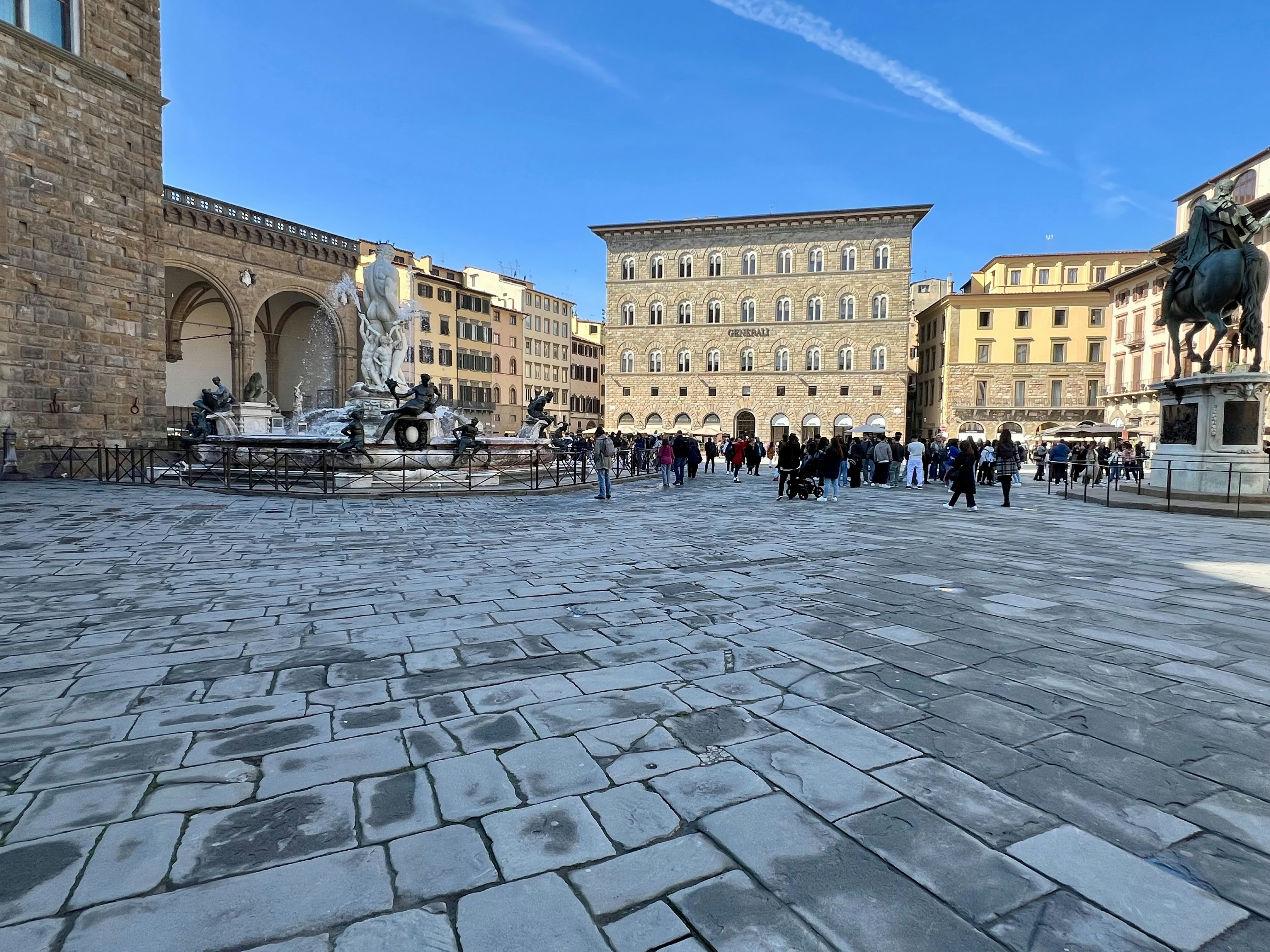A group of people walking around a stone courtyard