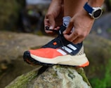 a person tying a shoelace on a rock