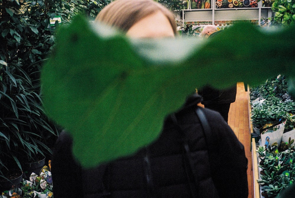 a woman in a greenhouse looking at plants