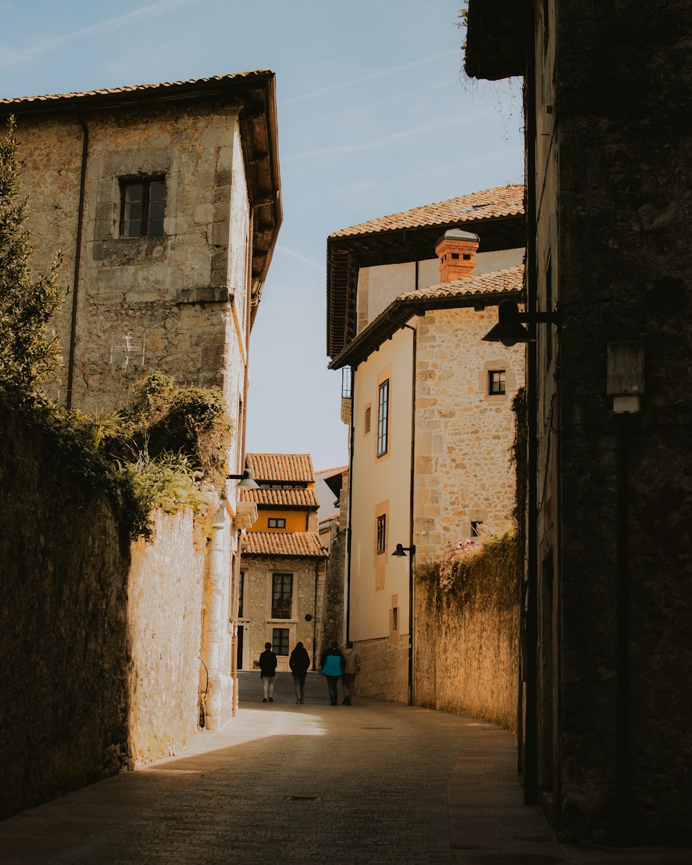 a couple of people walking down a narrow street