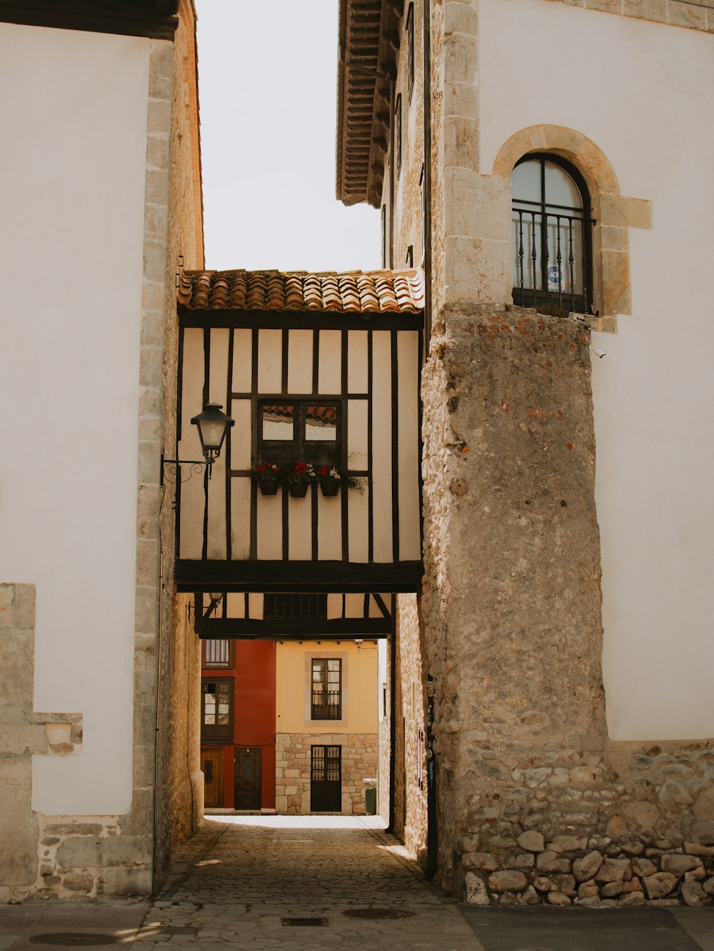 a narrow alley way with a clock on the wall