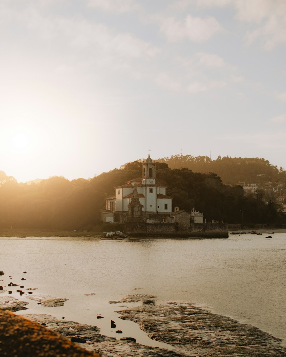 a body of water with a church on a hill in the background