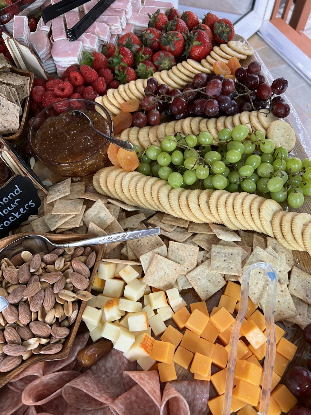 a variety of cheeses, crackers, nuts, and fruit