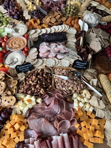 a large assortment of meats and cheeses on a table