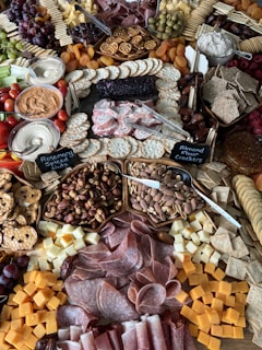 a large assortment of meats and cheeses on a table