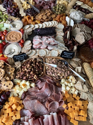 a large assortment of meats and cheeses on a table
