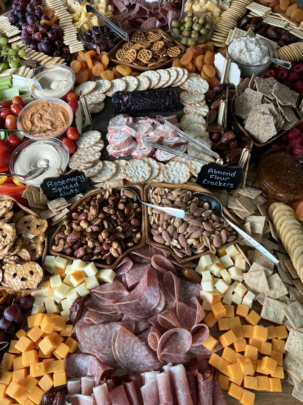 a large assortment of meats and cheeses on a table