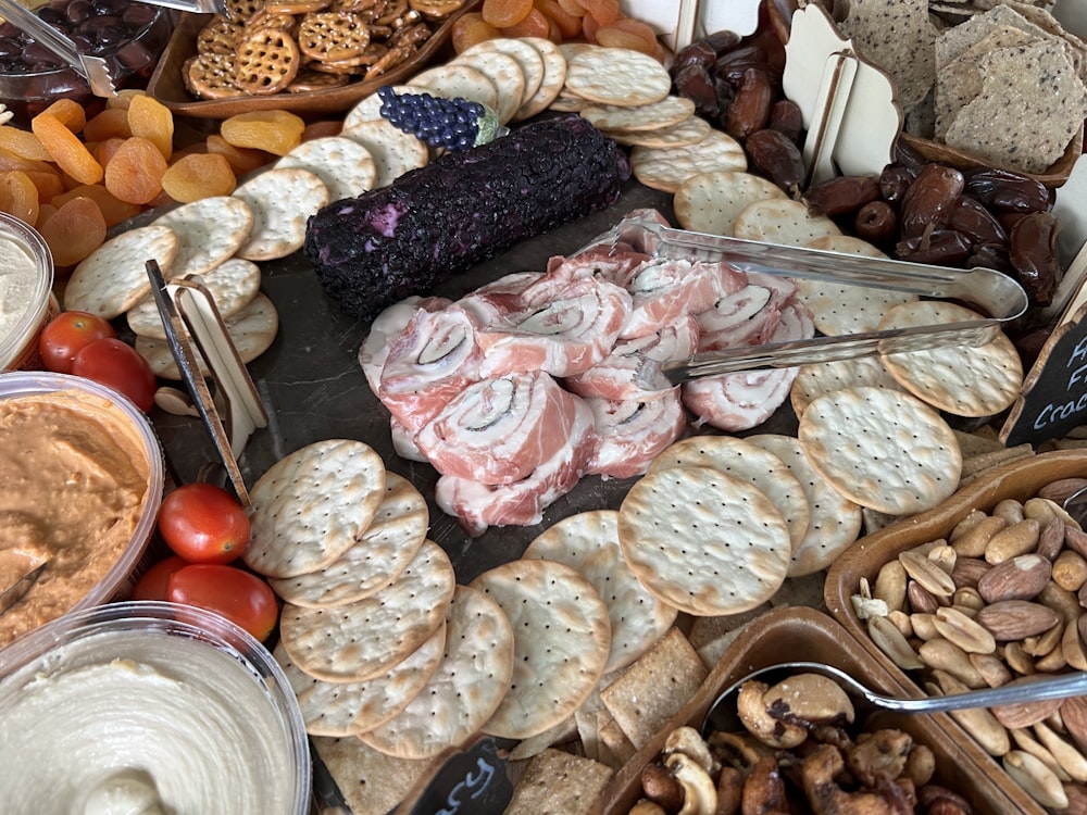 a platter of crackers, crackers, nuts, and dips