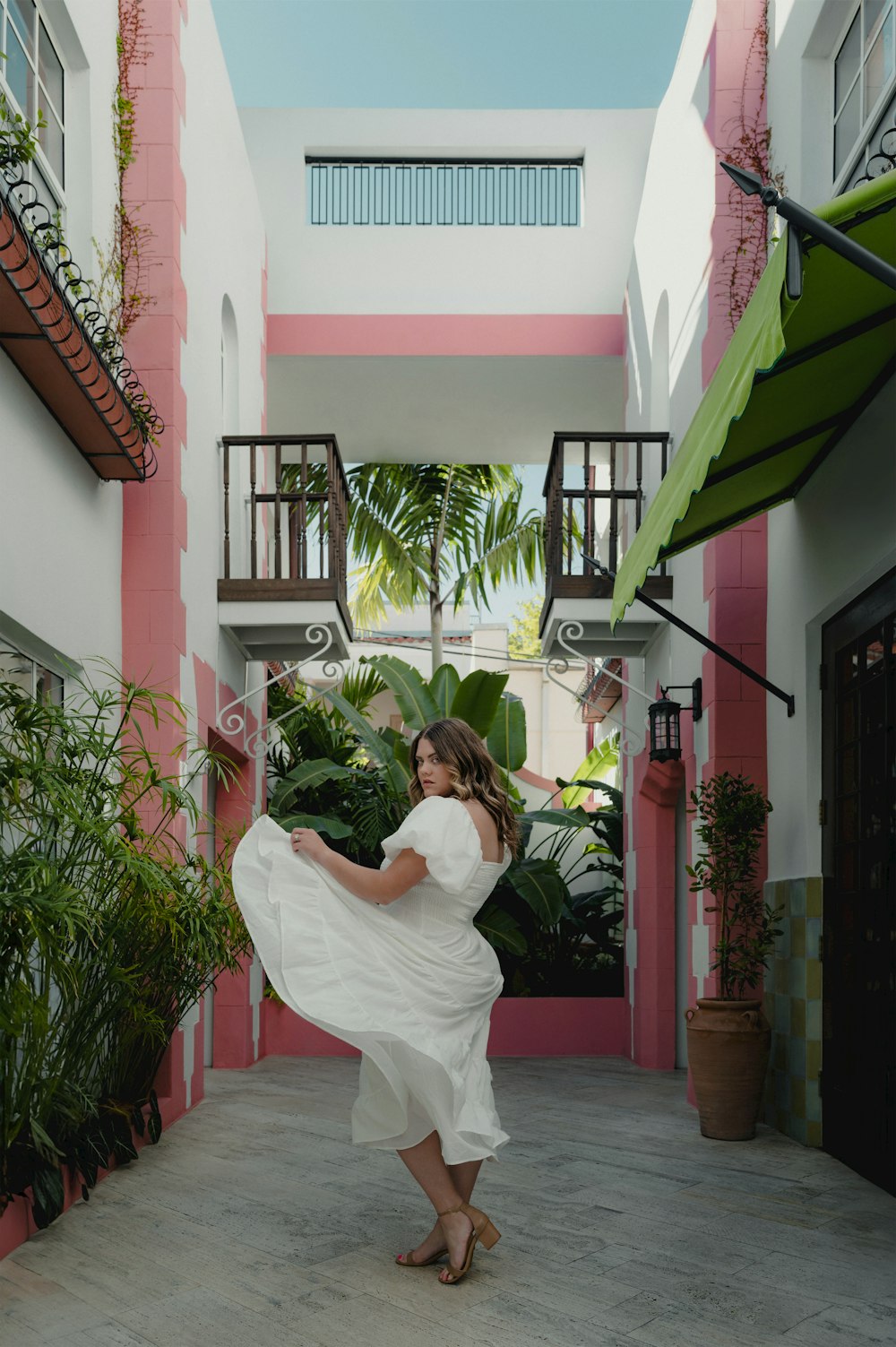 uma mulher em um vestido branco dançando em um pátio