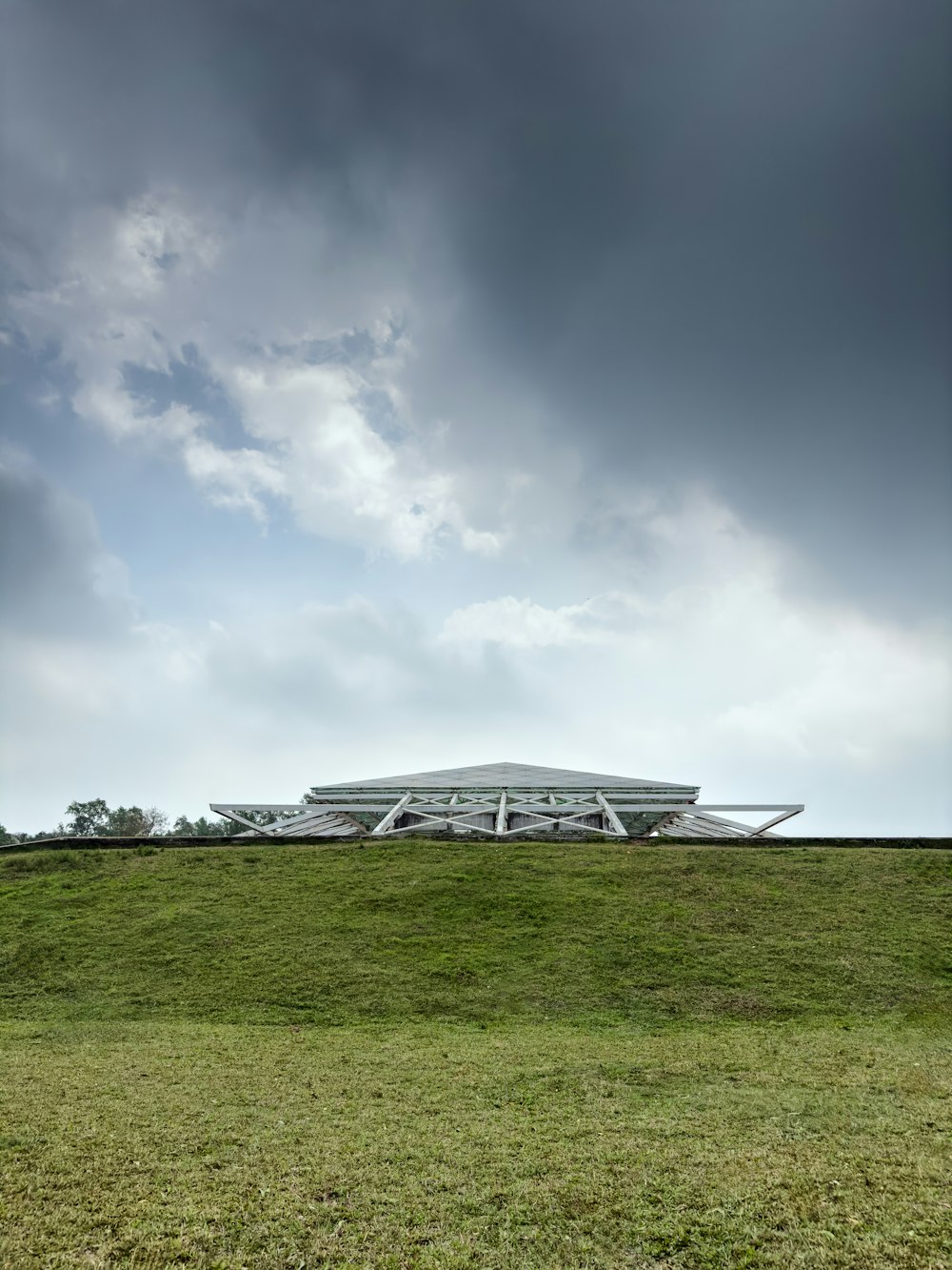 a large building on top of a lush green field