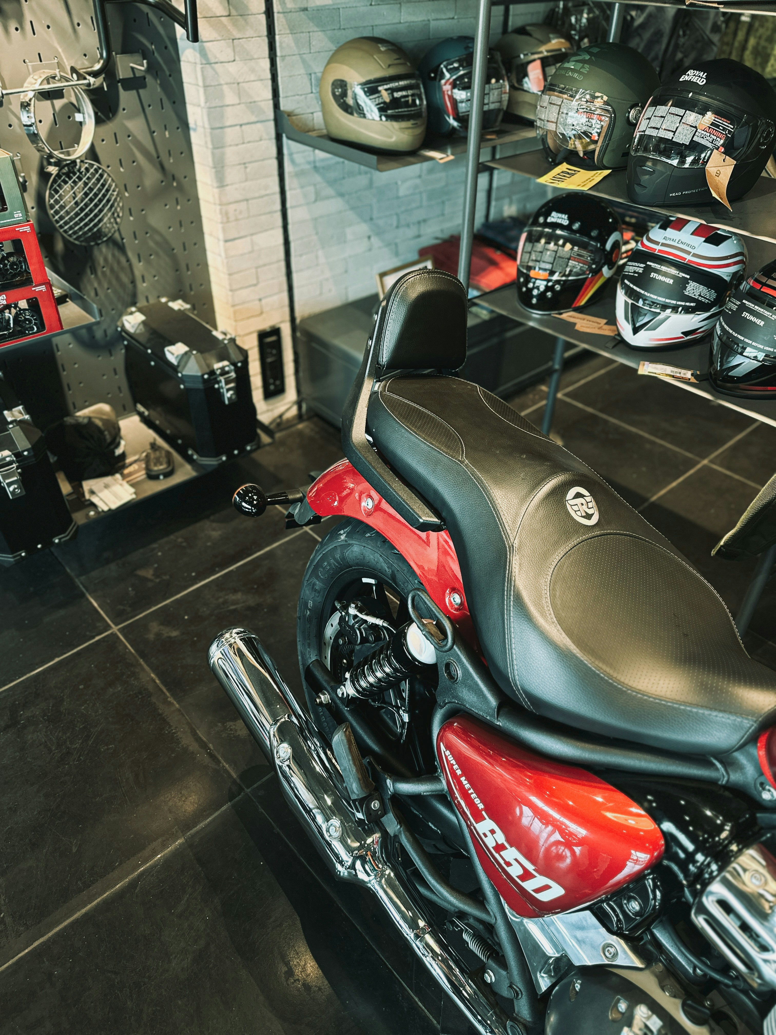 a red motorcycle parked in a garage next to other motorcycles
