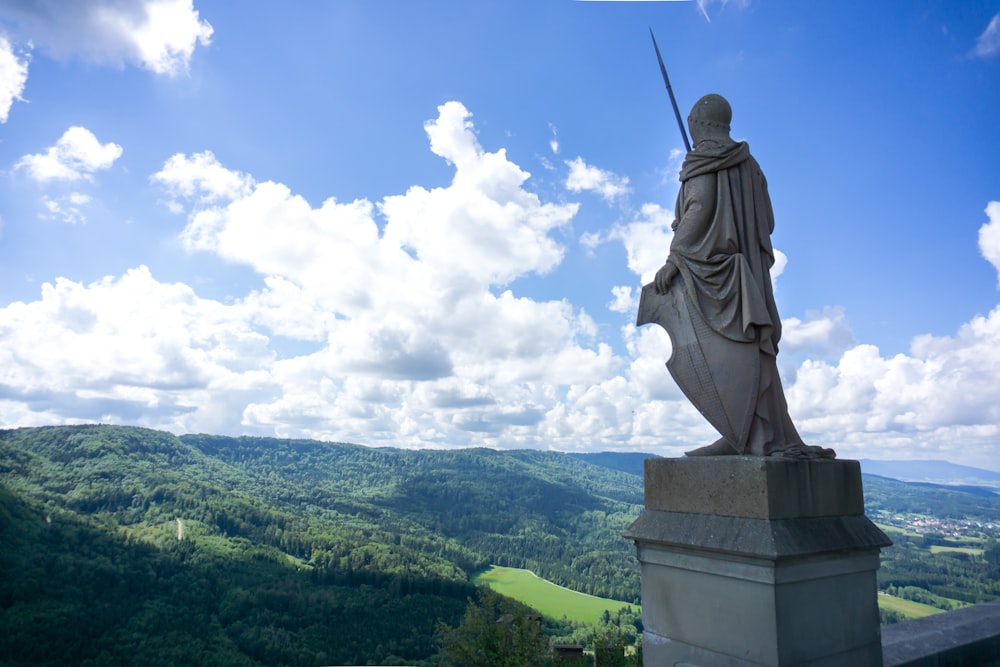 a statue of a man with a sword on top of a hill