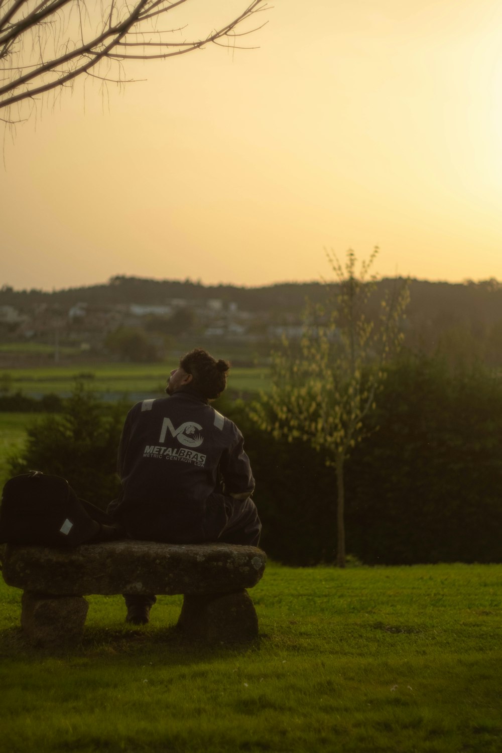 a person sitting on a bench in a field