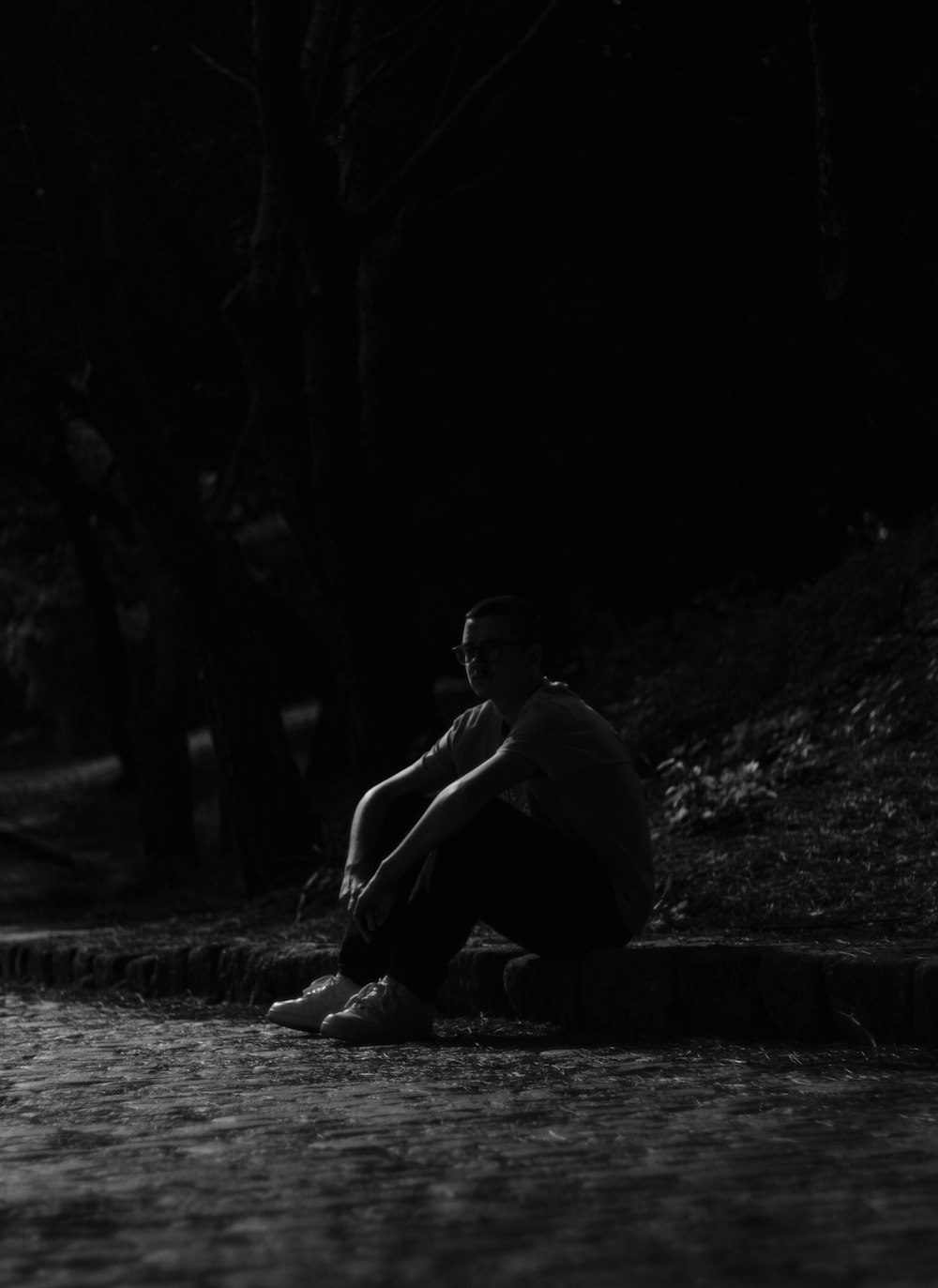 Ein Mann sitzt im Dunkeln auf dem Boden
