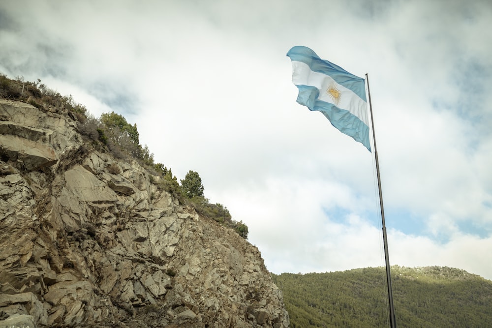 a flag flying on top of a rocky cliff