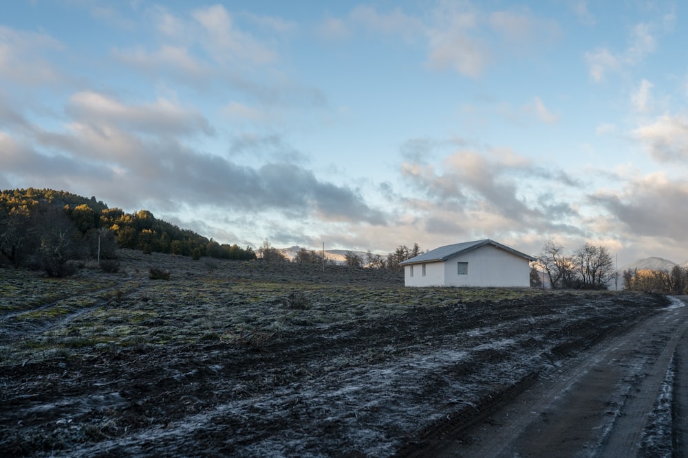 a dirt road with a house in the distance