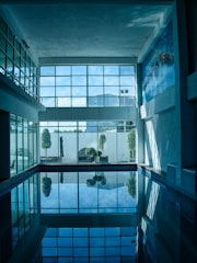 a swimming pool with a reflection of a building in it