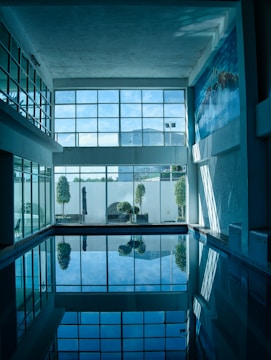 a swimming pool with a reflection of a building in it