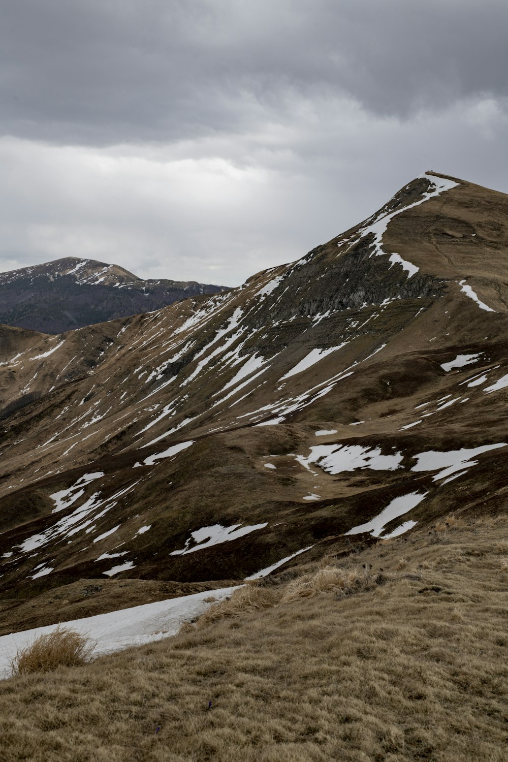 a couple of hills covered in snow under a cloudy sky