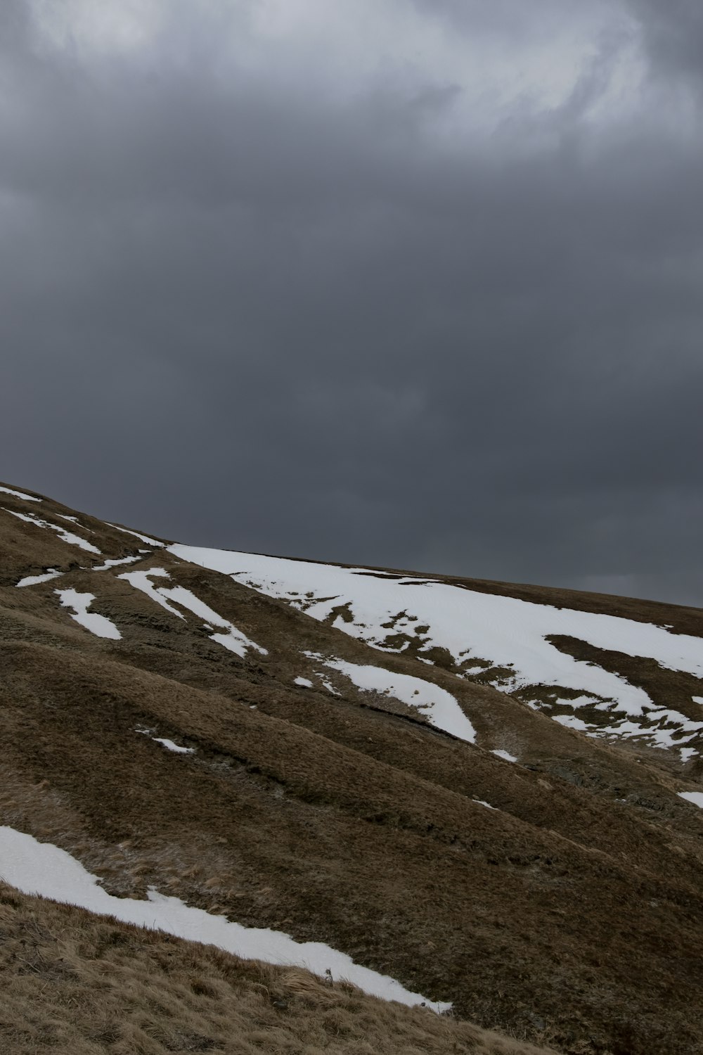 une colline couverte de neige sous un ciel nuageux