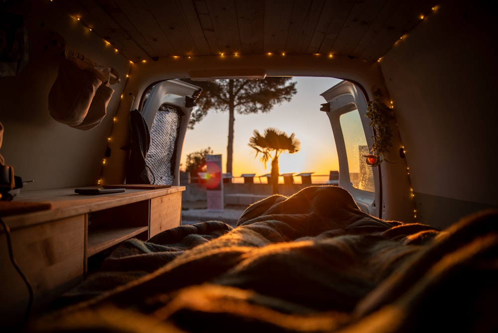 a camper van with the sun setting in the background