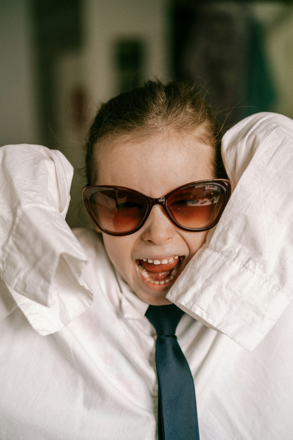 a woman wearing sunglasses and a tie covering her face