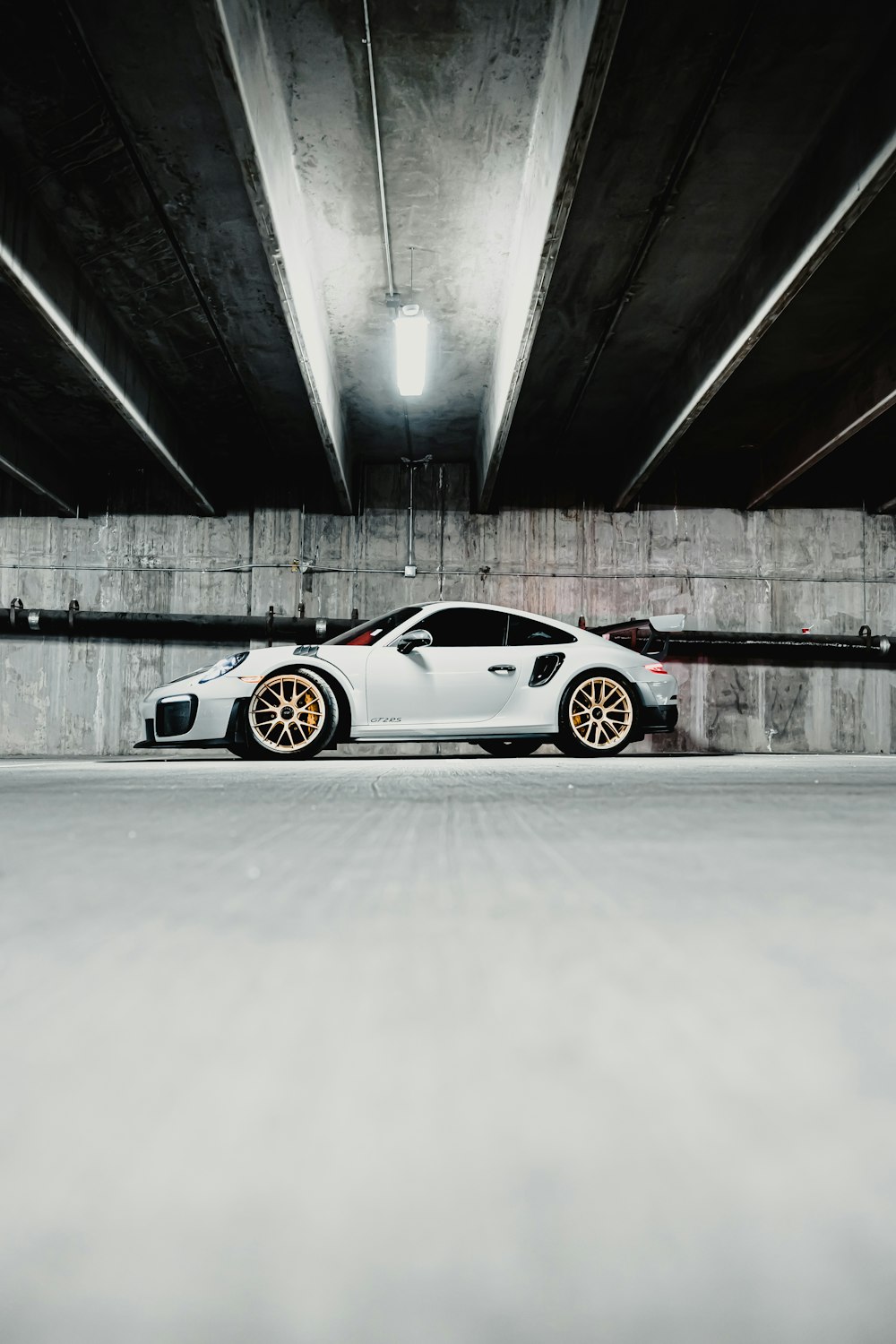 a white sports car parked in a parking garage