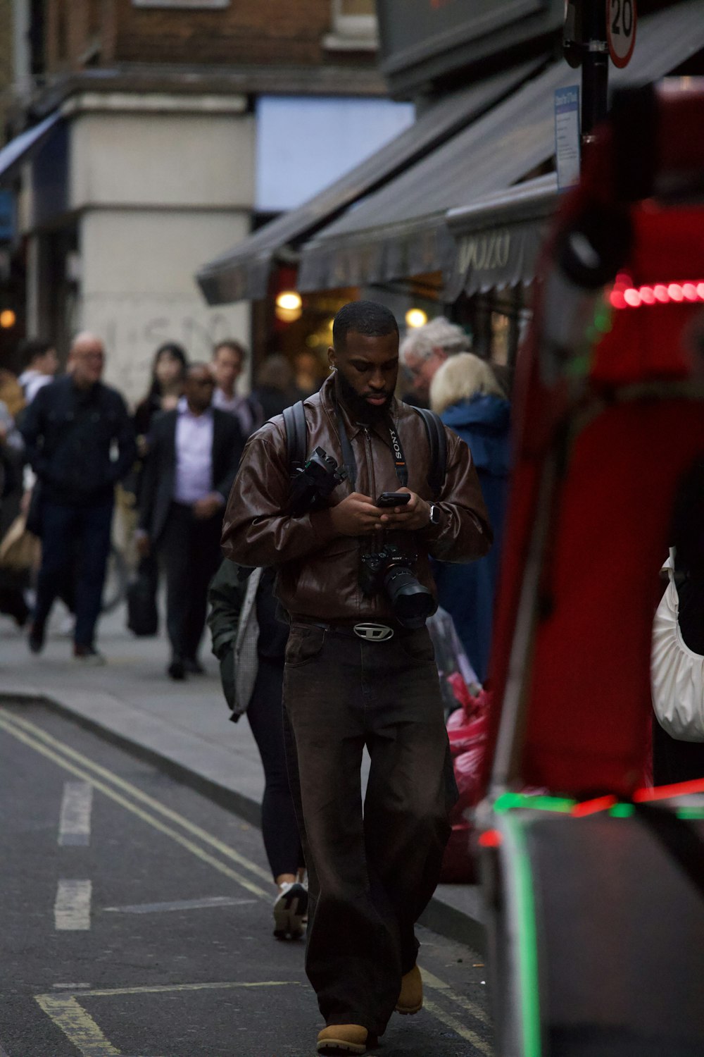 a man walking down a street while looking at his cell phone