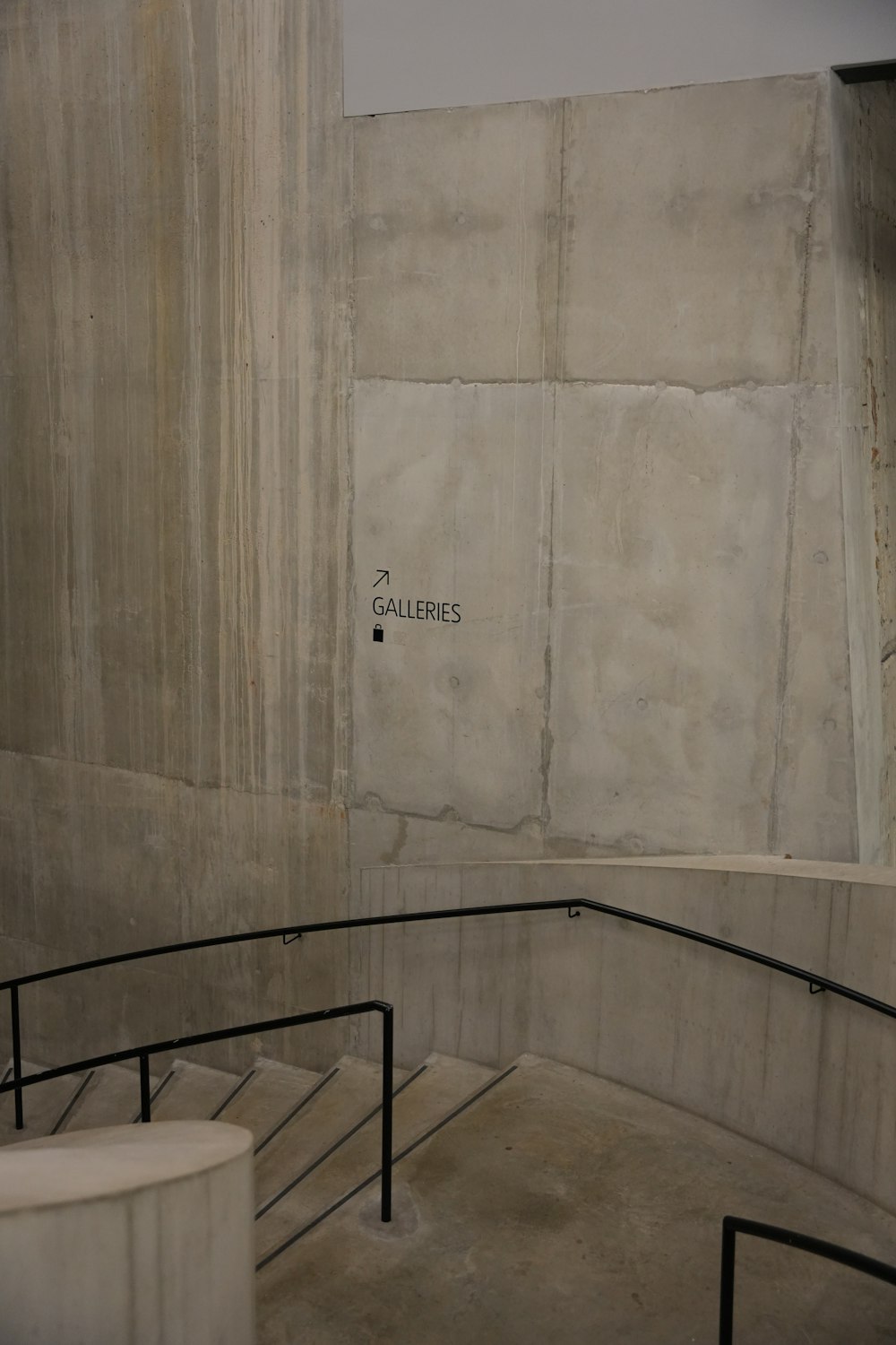 a concrete wall with a metal hand rail