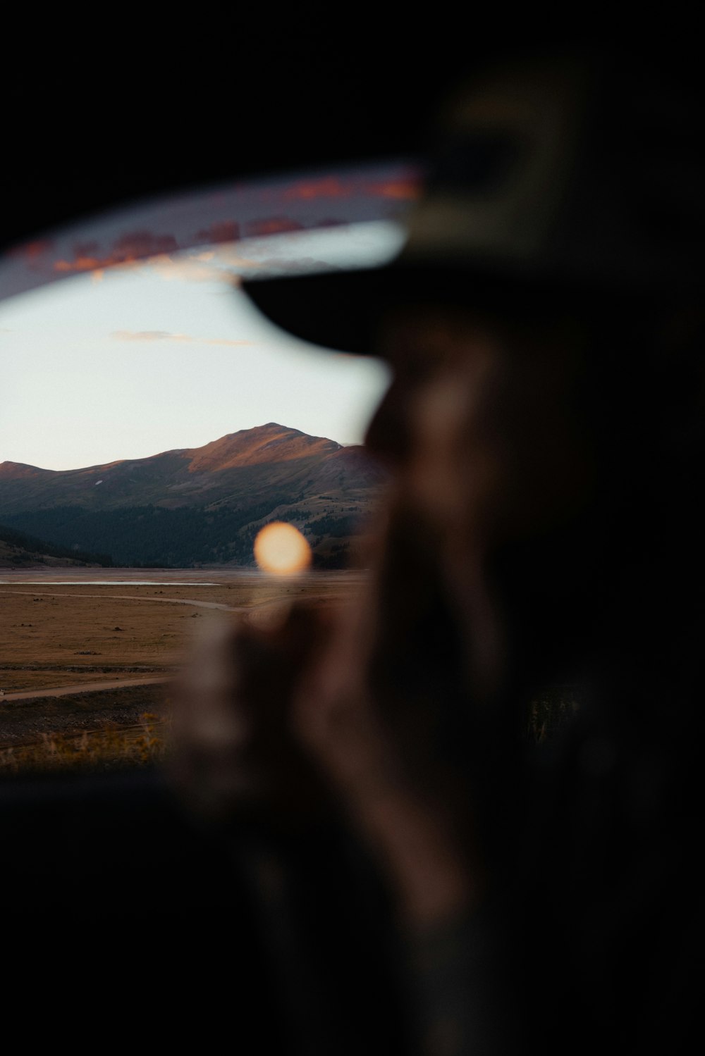 a man in a hat looking out a car window