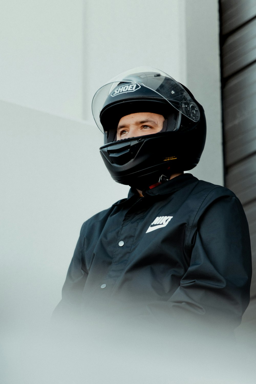 a man wearing a helmet standing next to a building