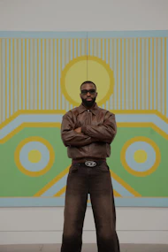 a man standing in front of a large painting