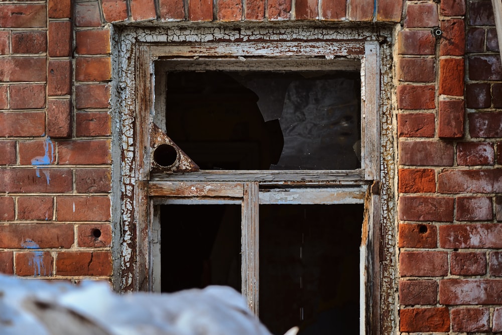 a broken window on a brick building