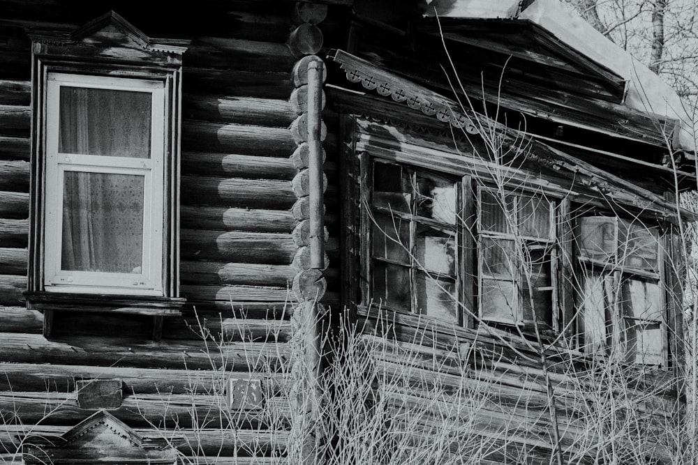 a black and white photo of an old log house