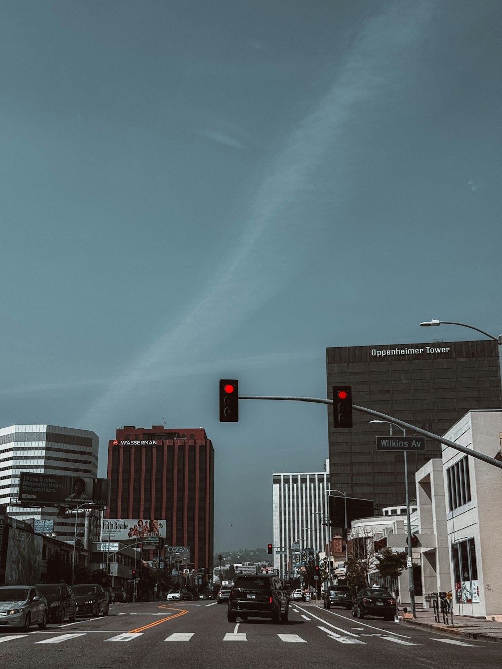 a red traffic light hanging over a city street