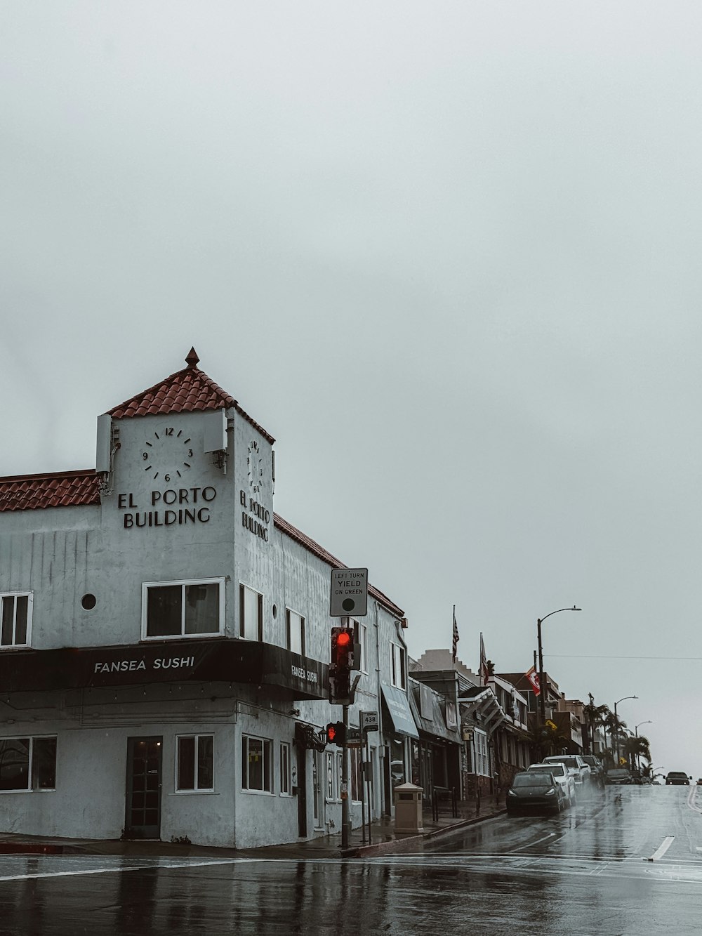 a wet street with buildings and a traffic light