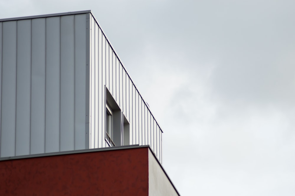 a red building with a window and a sky background