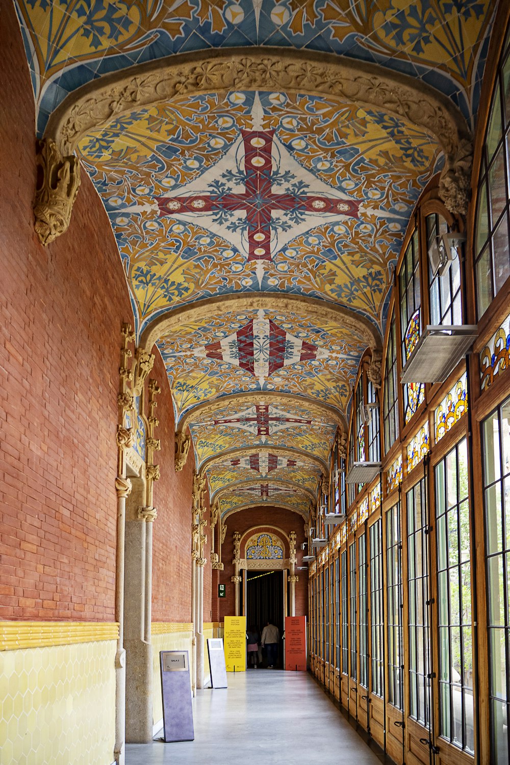 a long hallway with a painted ceiling and windows