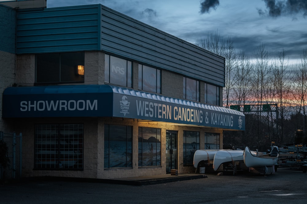 a building with a sign that says showroom and a boat in front of it
