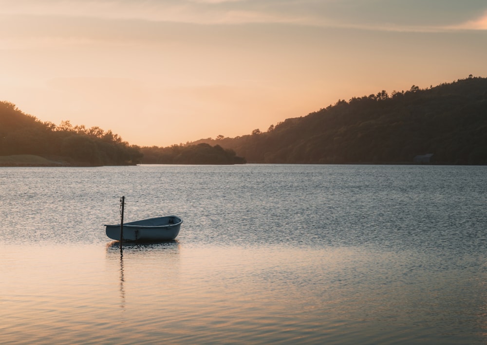 a small boat floating on top of a lake