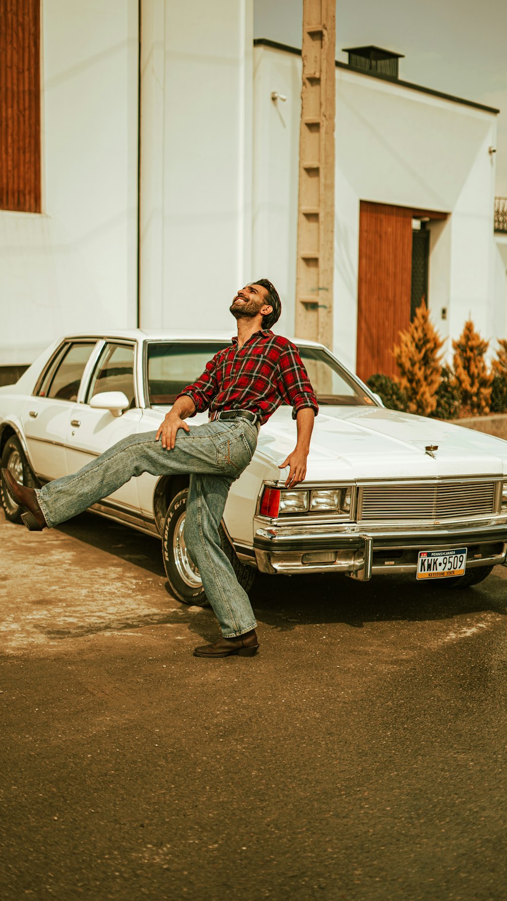 a man sitting on the back of a white car