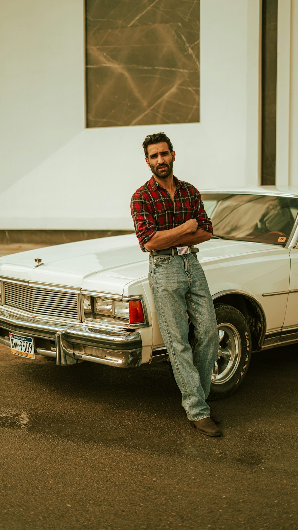 a man standing next to a white car