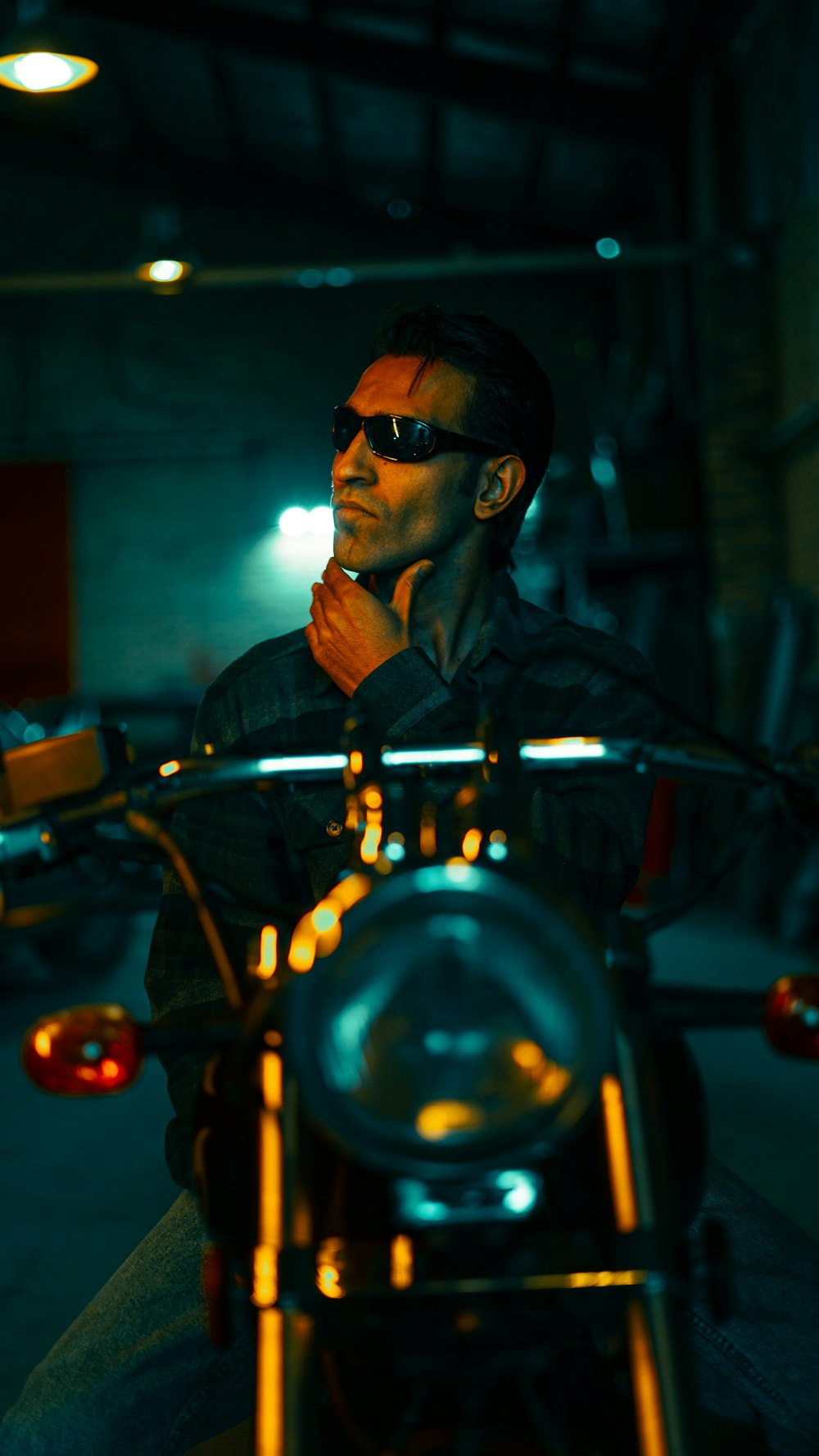a man wearing sunglasses sitting on a motorcycle