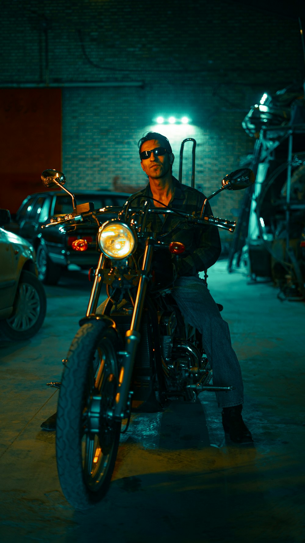 a man sitting on a motorcycle in a garage