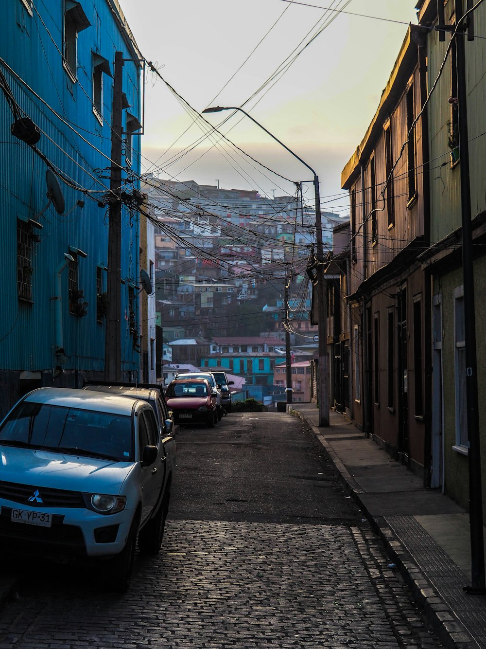 a car is parked on a cobblestone street