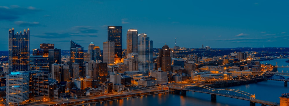 a view of a city at night with a bridge in the foreground