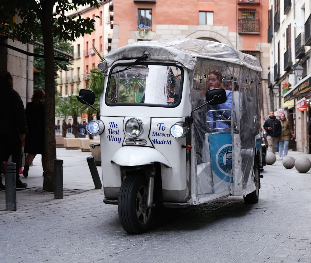 a man driving a small vehicle down a street