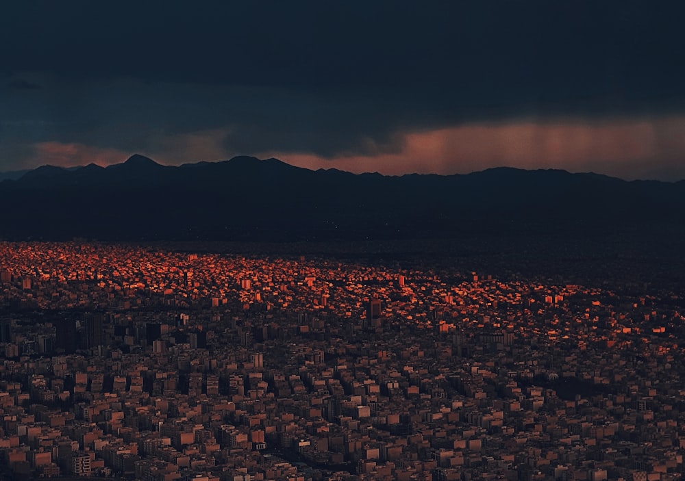 an aerial view of a city with mountains in the background