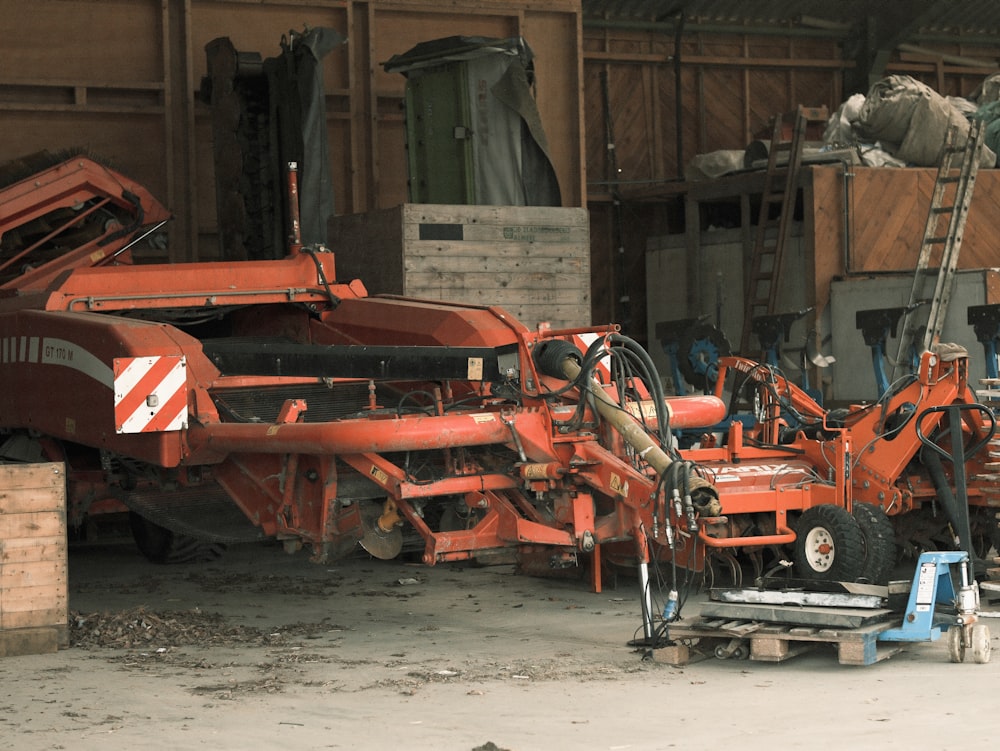 Un gros camion rouge garé à côté d’un tas d’ordures