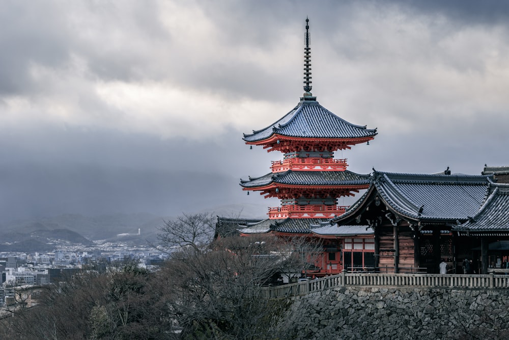 a tall building with a red roof on top of a hill